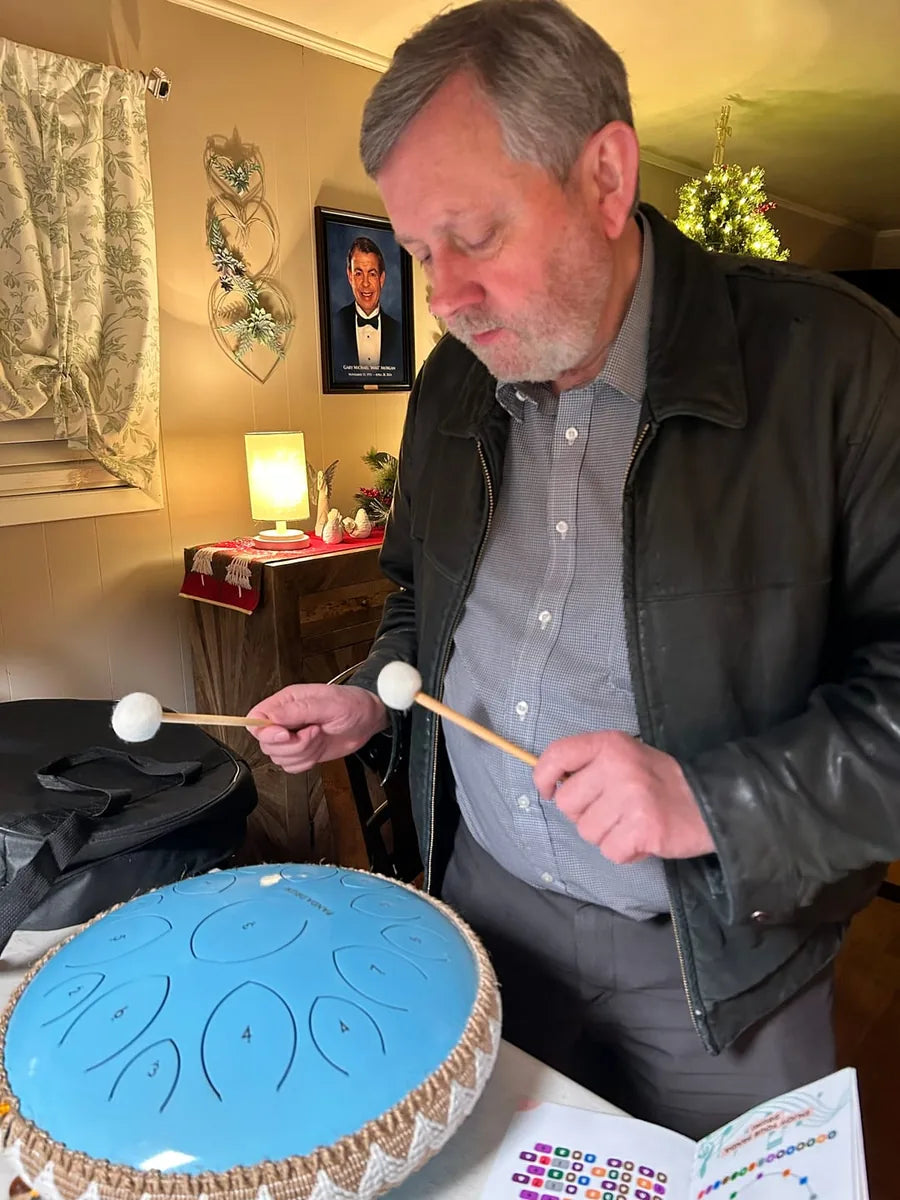An older customer playing his Panda Drum at home